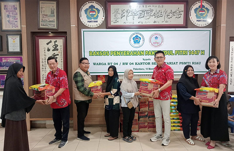 Ketua Harian PSMTI Riau Tohan didampingi pengurus lainnya menyerahkan bingkisan lebaran kepada warga sekitar sekretariat di Jalan Setiabudi Pekanbaru, Sabtu (14/3/2026). 