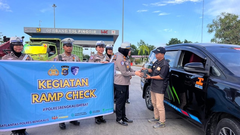 Kasatlantas Polres Bengkalis AKP Shandra Amalia menyerahkan bibit pohon kepada pengemudi kendaraan angkutan umum di pintu Exit Tol Pinggir, Kelurahan Balai Raja, Kecamatan Pinggir, Kabupaten Bengkalis