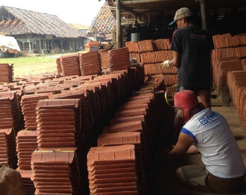 Dua pekerja genteng di Kecamatan Jatiwangi, Kabupaten Majalengka, Jawa Barat menyusun genteng yang diproduksi atas bantuan KUR BRI, baru-baru ini.
