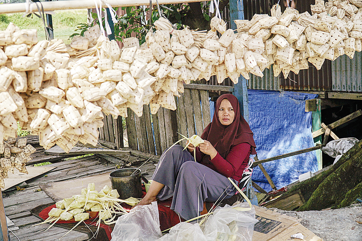 BUAT SARANG KETUPAT: Seorang pengrajin membuat sarang ketupat dari daun kapau di Kampung Bandar Senapelan, Kota Pekanbaru, Selasa (17/3/2026).