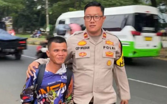 Kasie Humas Polres Karawang, Ipda Cep Wildan foto bersama pemudik asal Riau yang terpaksa berjalan kaki menuju Surabaya karena kehabisan ongkos. 