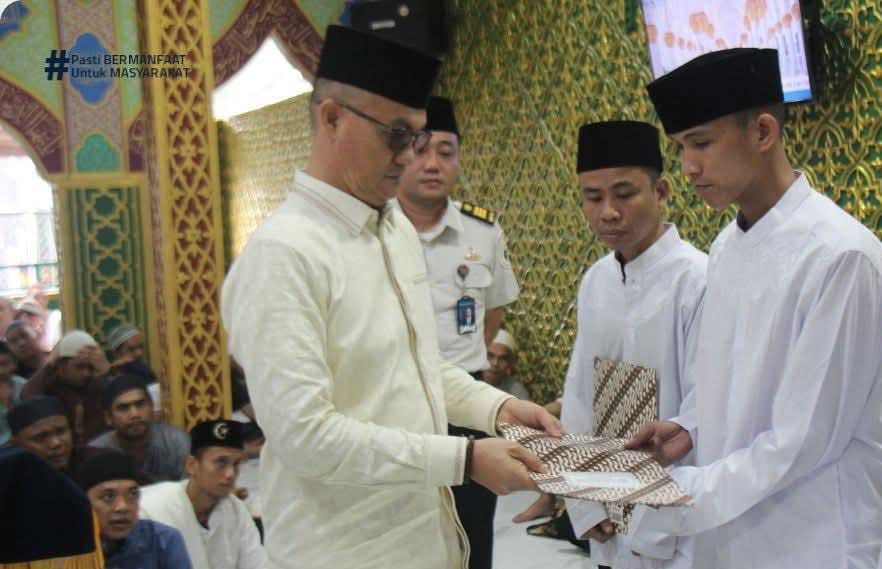 Kepala Lapas Kelas IIA Pekanbaru Yuniarto (kiri) menyerahkan remisi secara simbolis usai salat Idulfitri di Masjid At-Taubah Lapas pada Sabtu (21/3/2026).