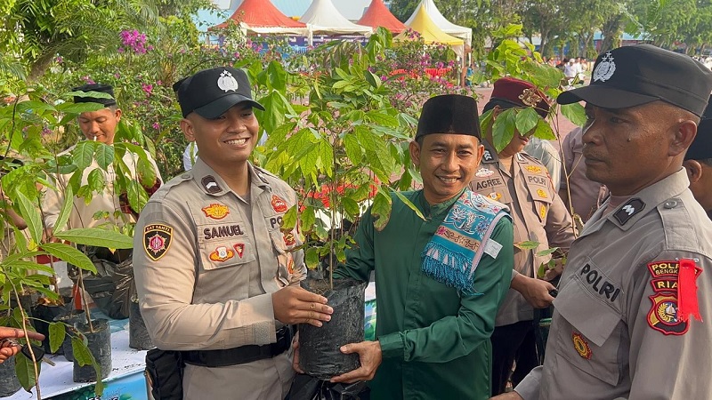 Personel Polres Bengkalis membagikan bibir pohon kepada jamaah Salat Idul Fitri di Lapangan Tugu Bengkalis, Sabtu (23/3/2026).