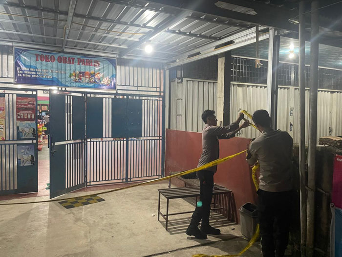 Tim Opsnal Polres dan Polsek Siak memasang garis polisi di toko lokasi perampokan di Simpang Suak Rengas, Kelurahan Sungai Mempura, Kecamatan Mempura, Kabupaten Siak, Jumat (20/3/2026). 