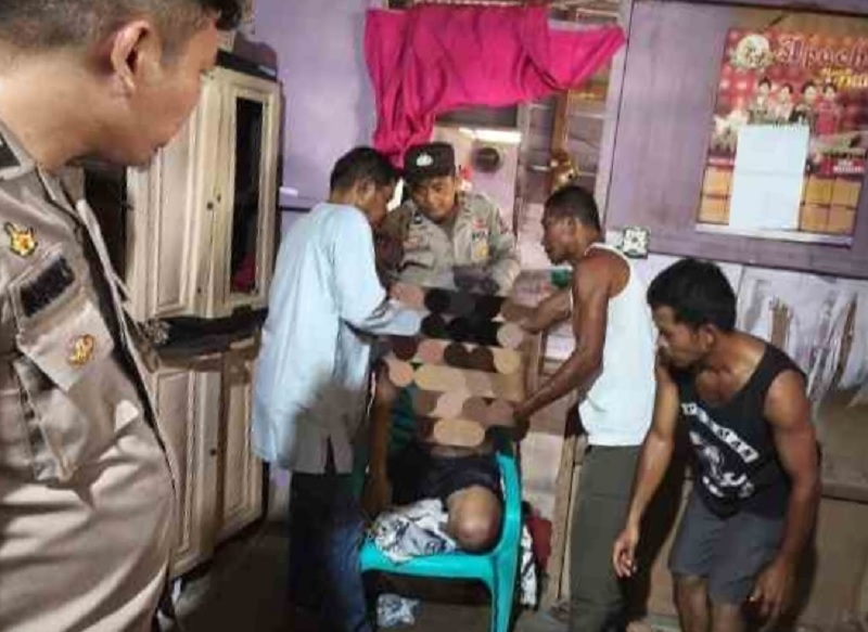 Petugas polisi dan warga membantu mengevakuasi korban gantung diri dalam rumahnya di Jalan Bhatin Tomat, RT/RW 02/04 Desa Semunai, Kecamatan Pinggir, Bengkalis, Sabtu (21/3/2026) siang.