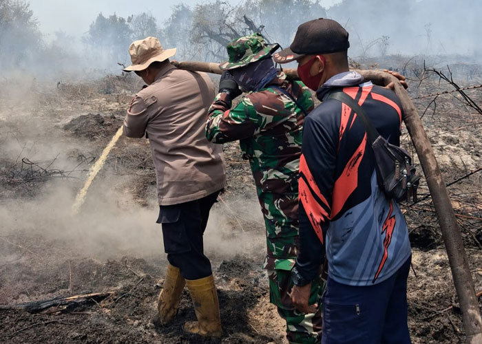 Kapolsek Rupat AKP Faisal bersama tim Satgas Karhutla melakukan pendinginan di Jalan Parit Jawa Dusun Sungai Mesim dan di Jalan Sukajadi Desa Sukarjo Mesim Kecamatan Rupat, Senin (23/3/2026).