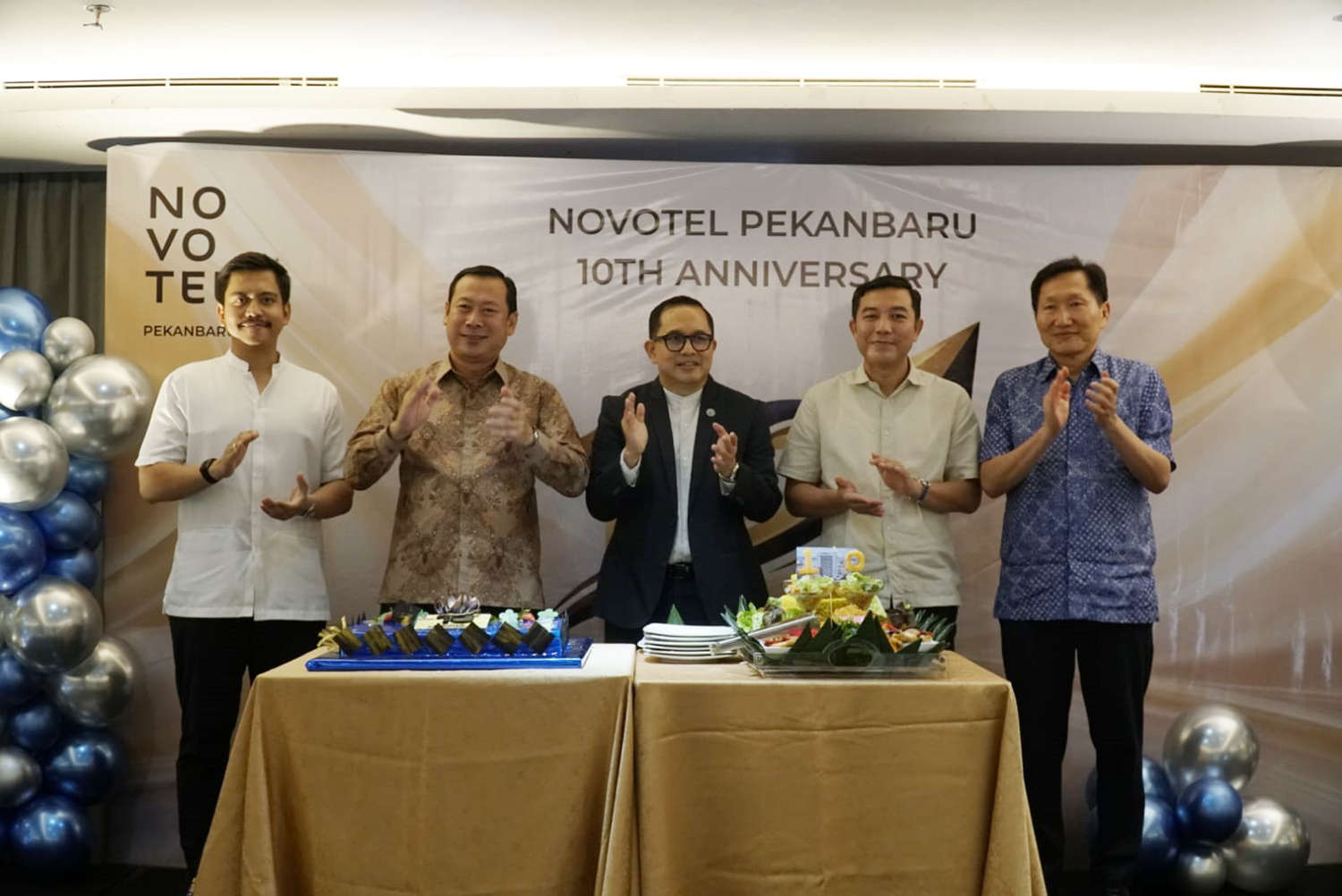 General Manager Novotel Pekanbaru Sentot Lasiyanto (tengah) dan jajaran direksi dan komisaris saat merayakan hari jadi ke-10 tahun Novotel Hotel dengan melakukan pemotongan tumpeng di Pekanbaru, Selasa (24/3/2026). 