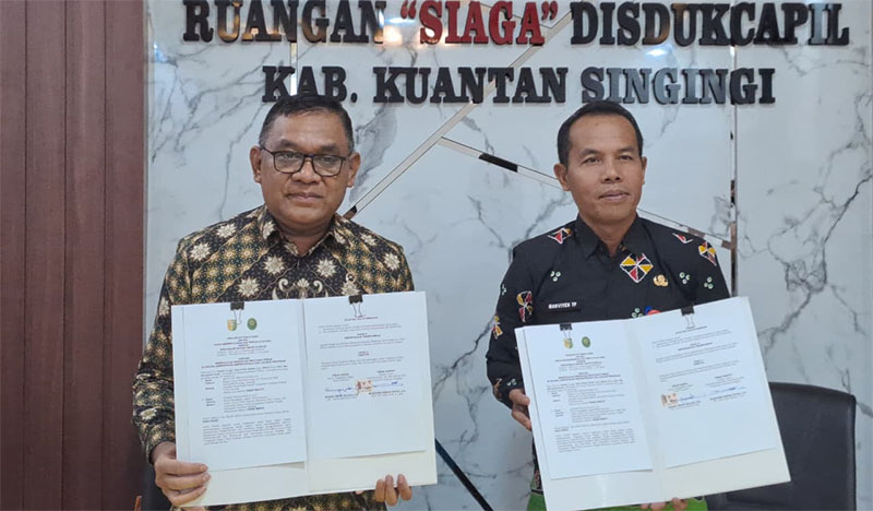 Ketua PN Teluk Kuantan Subiar Teguh Wijaya SH (kiri) dan Kadisdukcapil Mahviyen Trikon Putra memperlihatkan kerja sama administrasi kependudukan, Kamis (26/3/2026). 