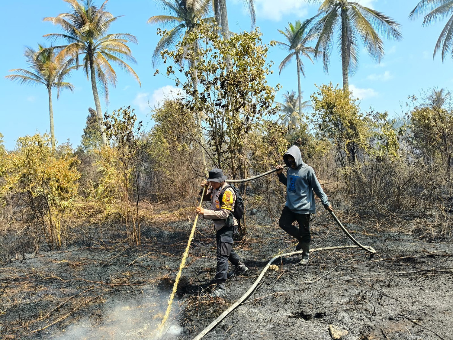 Personel Polsek Rangsang, Kepulauan Meranti, memadamkan api yang membakar lahan di Desa Tanjung Bakau, Kecamatan Rangsang, Kamis (26/3/2026).
