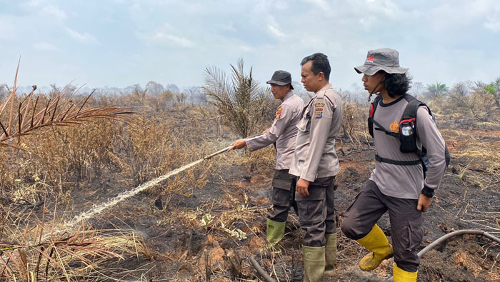 Personel Polres Inhu saat melakukan pendingan atas lahan yang terbakar di Kelurahan Sekip Hilir Kecamatan Rengat, Kamis (26/3/2026).