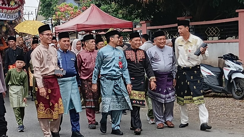 Sekda Kuansing Zulkarnain bersama bersama sejumlah pejabat di lingkungan Pemkab Kuansing ikut berjalan kaki ke rumah godang saat perayaan tradisi Rayo Onam Baserah Kecamatan Kuantan Hilir, Sabtu.
