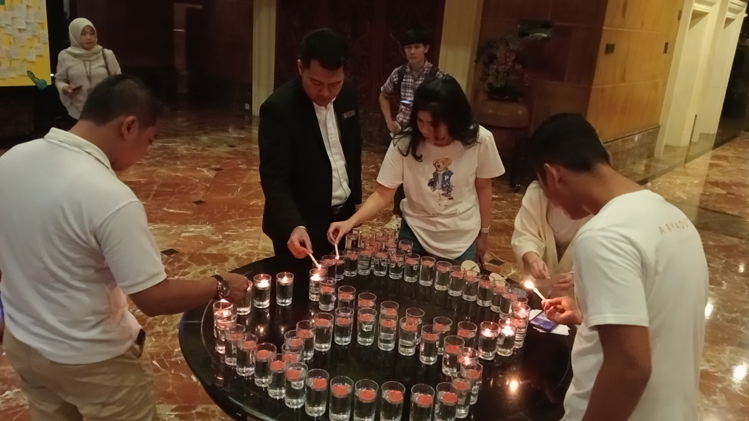 Manajemen Aryaduta Pekanbaru ikut menyalakan lilin berangka  60++ saat kegiatan Earth Hour, Sabtu (28/3/2026). 