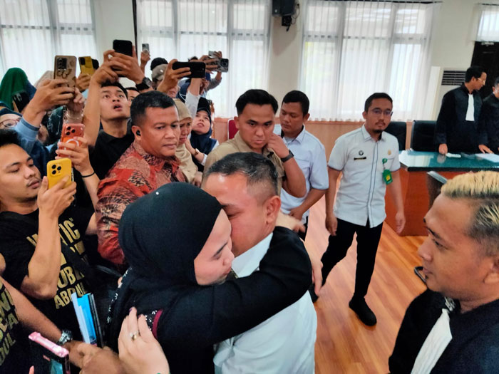 Gubernur Riau nonaktif Abdul Wahid menghampiri istri Henny Sasmita saat menjalani sidang perkara korupsi di Pengadilan Negeri Pekanbaru Kelas 1A, Senin  (30/3/2026).