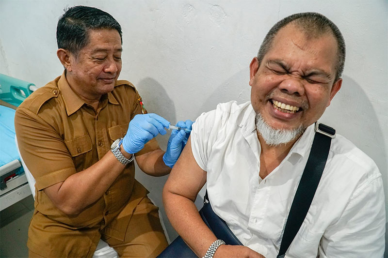 JCH Pekanbaru meringis ketika disuntik vaksin oleh dokter di Puskesmas Simpangtiga, Senin (30/3/2026). 