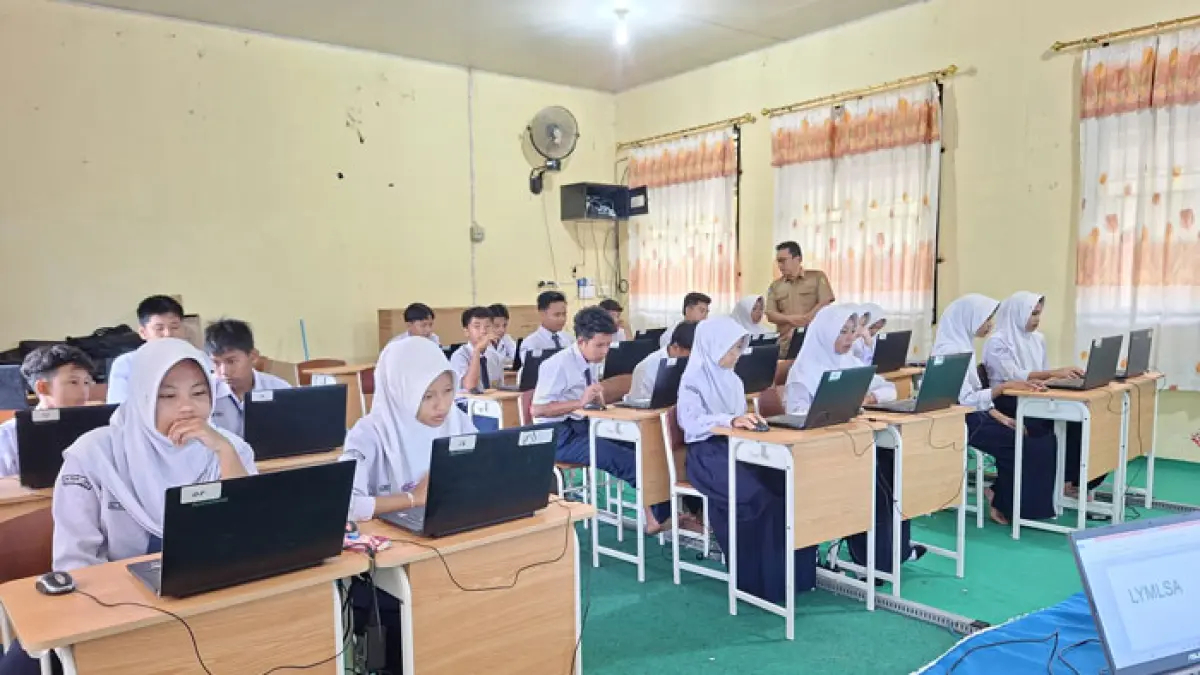 Staf Disdikpora Kuansing melakukan peninjauan pelaksanaan TKA di SMPN 1 Kecamatan Logas Tanah Darat, Senin (6/4/2026). (Desriandi Candra/Riaupos.co)