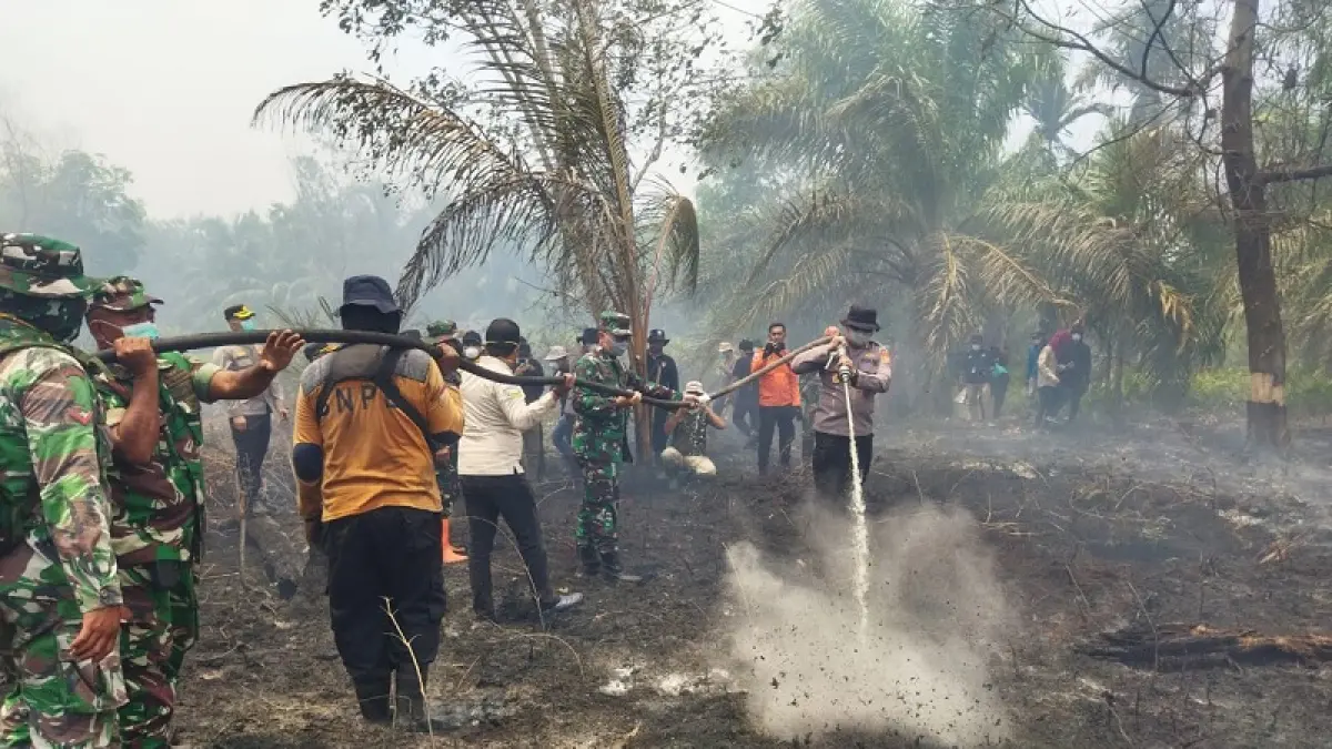 Pascadiguyur hujan deras, petugas gabungan tetap melakukan pendinginan api karhutla di Desa Kembung Baru, Kecamatan Bantan, Bengkalis, Selasa (7/4/2026) siang.(Bhabinkamtibmas Kembung Luas for Riau Pos)