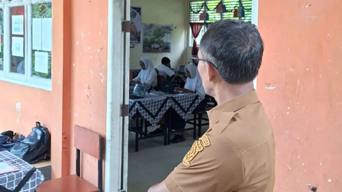 Plt Kadisdikpora Helmi meninjau pelaksanaan TKA di UPT SMPN 2 Kuok, Kecamatan Kuok, Kabupaten Kampar, Senin (6/4/2026). (Disdikpora Kampar untuk Riaupos.co)