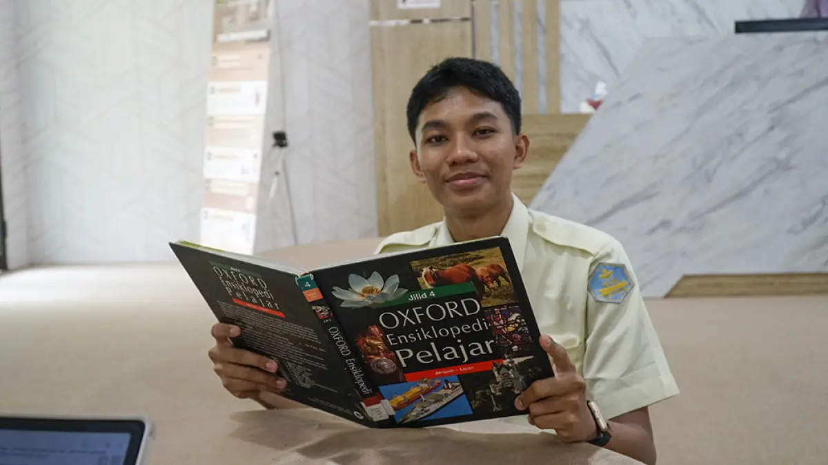 Siswa MAN 2 Pekanbaru M Arief Hidayat Annas membaca buku saat ditemui Riau Pos, Selasa (7/4/2026). (MHD AKHWAN/RIAUPOS)