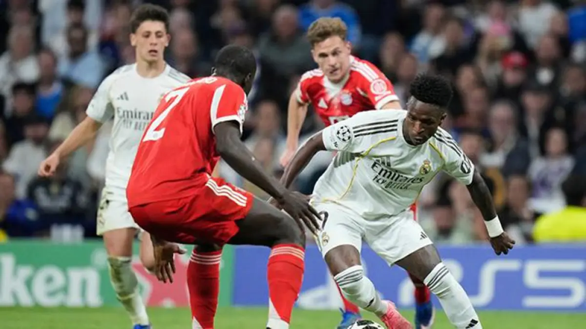 Duel perebutan bola terjadi antara Vinicius Junior (kanan) dan Dayot Upamecano dalam laga leg pertama perempat final Liga Champions antara Real Madrid dan Bayern Munchen di Santiago Bernabeu, Rabu (8/4/2026). (Bernat Armangue/AP Photo)
