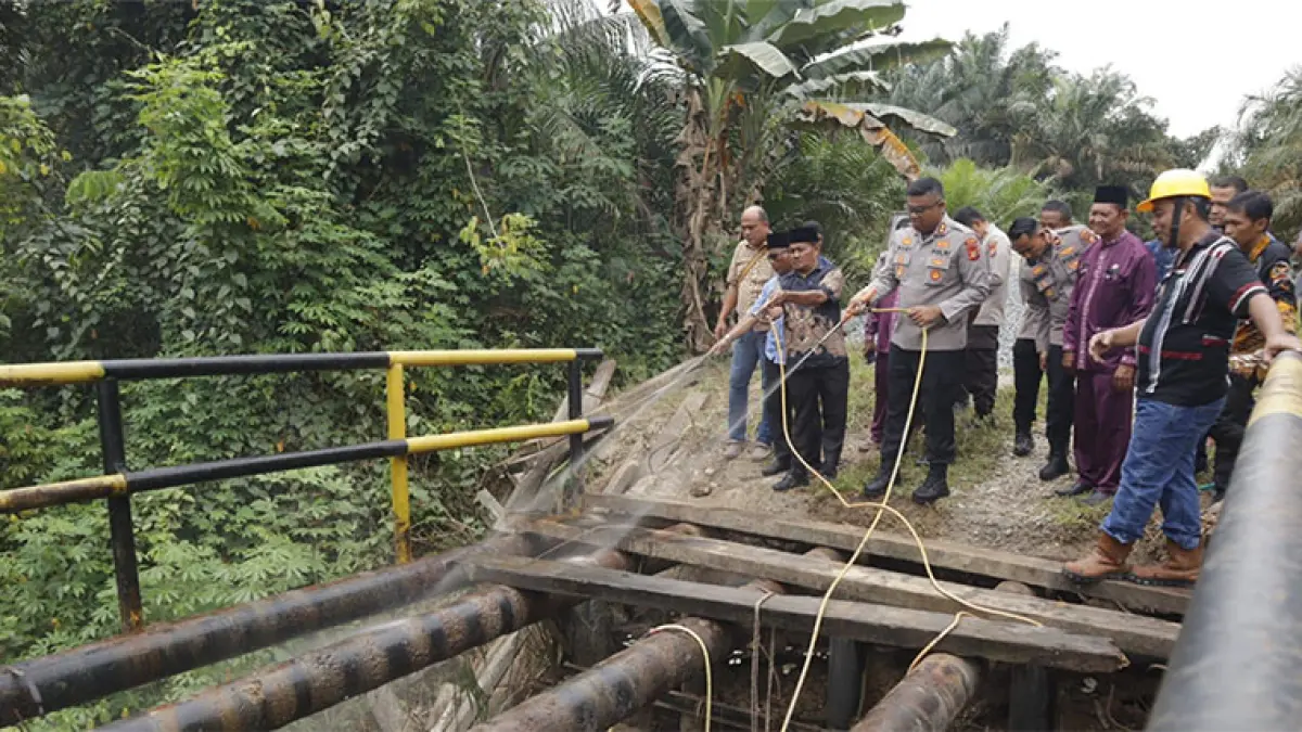 Kapolres Kampar AKBP Boby Putra Ramadhan Sebayang membersihkan jembatan Dusun Pulau Jambu, Desa Pulau Jambu, Kabupaten Kampar, Kamis (9/4/2026). Humas Polres Kampar untuk Riaupos.co
