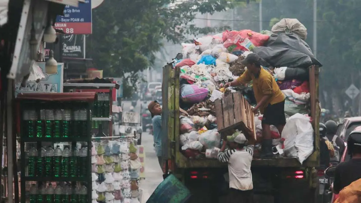 Pekerja mengangkut sampah ke dalam truk di kawasan Jalan Kaharuddin Nasution, Pekanbaru. (DOK RIAUPOS.CO) 
