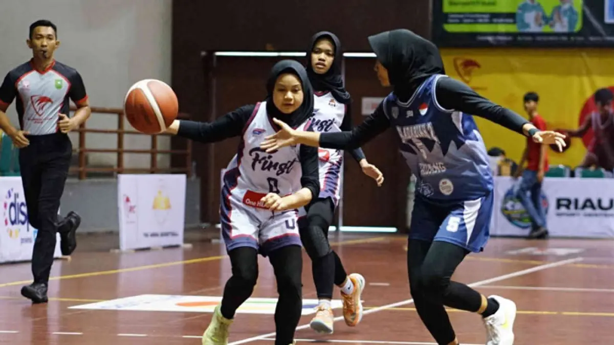 Pemain SMAN 1 Pekanbaru berusaha lepas dari penjagaan pemain SMA Adabiah 2 Padang saat pertandingan Turnamen Rajawali Cup IV 2026 di Gelanggang Olahraga Tribuana Pekanbaru, Kamis (9/4/2026). (Evan Gunanzar/Riau Pos)