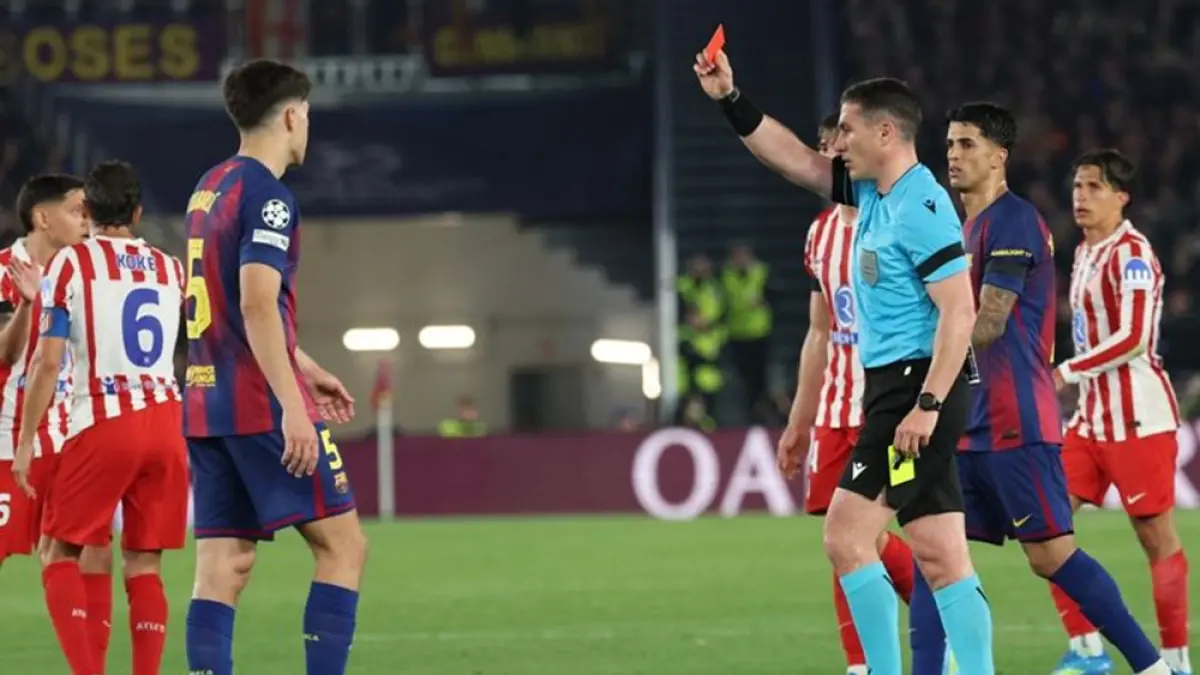 Bek Barcelona, Pau Cubarsi (kiri), menerima kartu merah dari wasit asal Rumania, Istvan Kovacs, pada laga leg pertama perempat final Liga Champions antara FC Barcelona melawan Atletico Madrid di Stadion Camp Nou, Barcelona, Kamis (9/4/2026). (LLUIS GENE/AFP)
