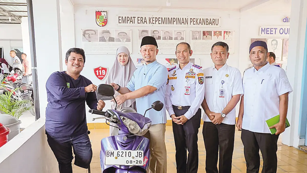 Sandro Gutmen Manurung (kiri) menerima sepeda  motor pengganti dari Wali Kota Pekanbaru Agung Nugroho, Rabu (8/4/2026). (Pemko Pekanbaru)
