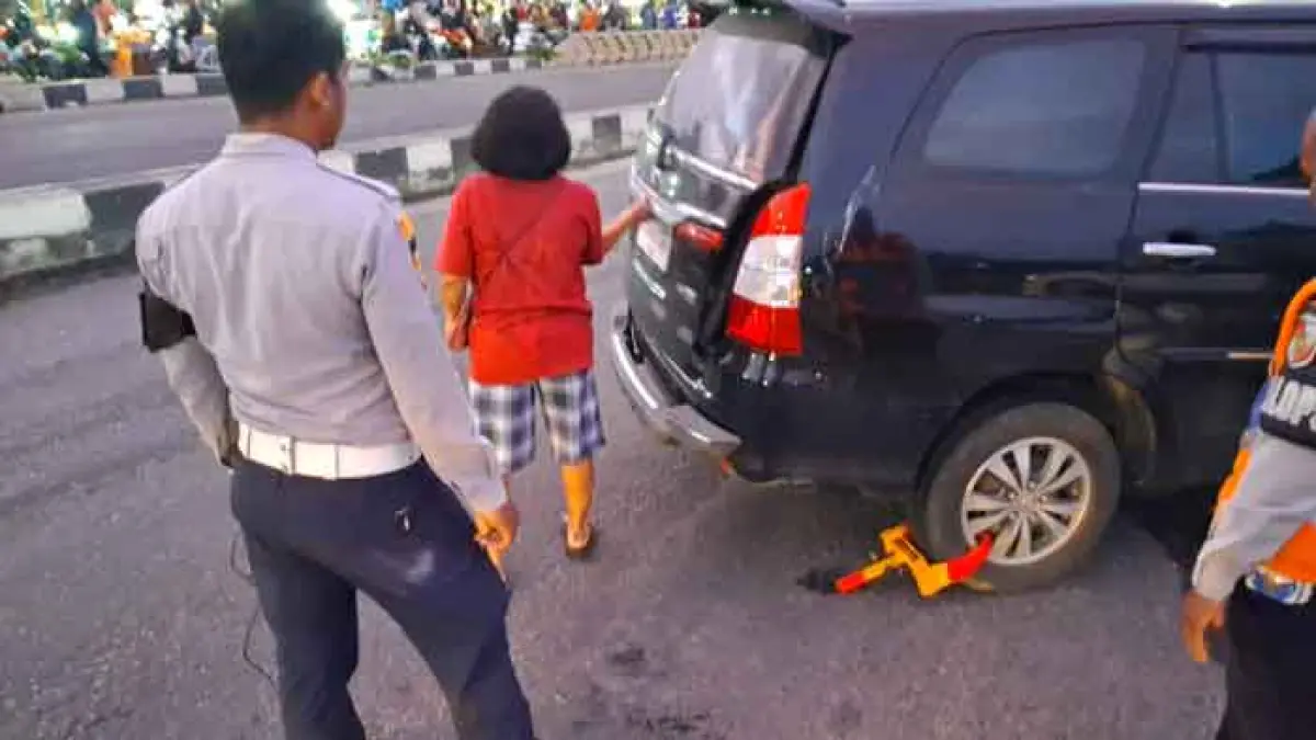 Petugas Dishub Kota Pekanbaru melakukan penggembokan terhadap roda kendaraan roda empat yang parkir sembarangan di Jalan  Soekarno Hatta, depan Pasar Pagi Arengka, Jumat (10/4/2026) pagi. DISHUB PEKANBARU UNTUK RIAUPOS.CO