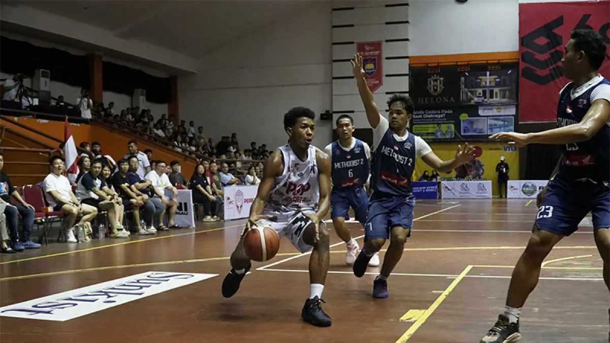 Pemain SMA PPOP Jakarta berusaha melewati pengawalan pemain SMA Methodist 2 Medan saat pertandingan Turnamen Rajawali Cup IV 2026 di GOR Tribuana Pekanbaru, Sabtu (11/4/2026). EVAN GUNANZAR/RIAU POS
