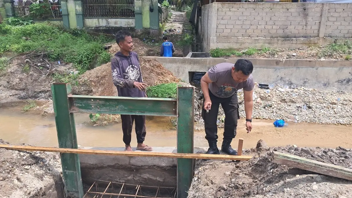 Personel Polres Kuansing dan warga menggesa pembangunan jembatan Merah Putih Persisi di Desa Logas Kecamatan Singingi, Sabtu (11/4/2026). (Polres Kuansing)