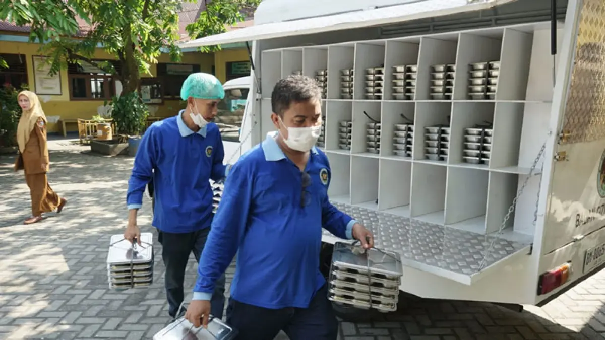 Petugas membawa ompreng untuk didistribusikan ke sekolah SDN 99 Jalan Durian Pekanbaru, beberapa waktu lalu. (Evan Gunanzar/Riau Pos)