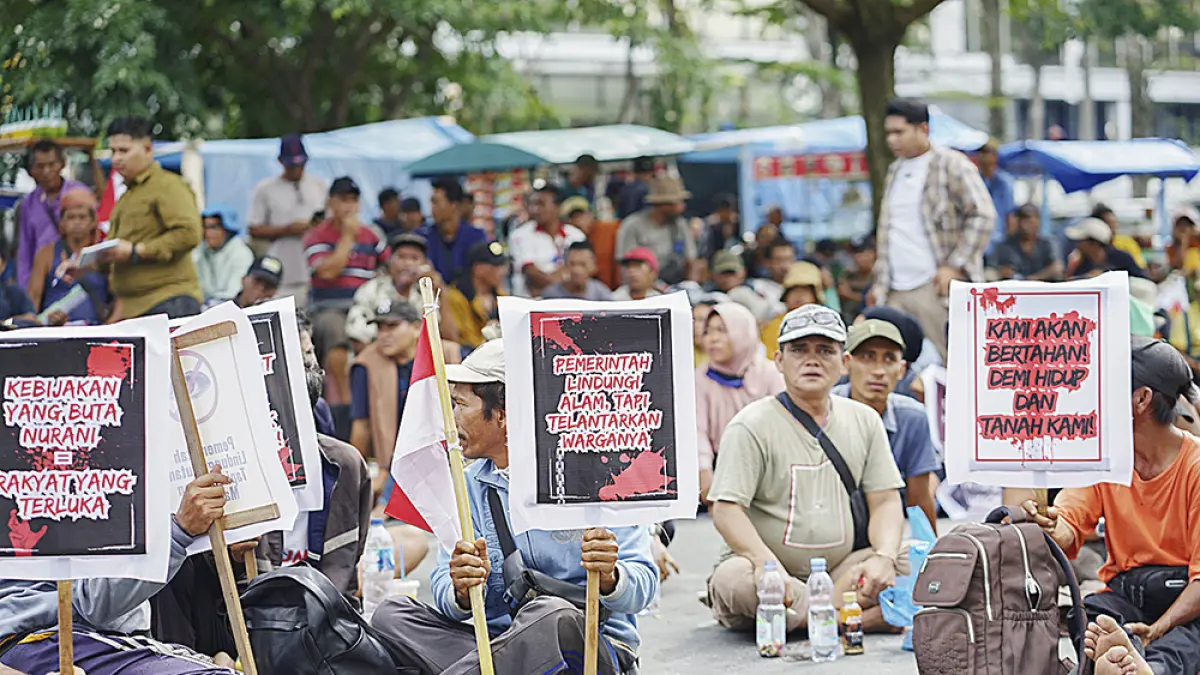 Aliansi Mahasiswa dan Masyarakat Pelalawan menggelar aksi menolak relokasi dari Taman Nasional Tesso Nilo di pintu samping Kantor Gubernur Riau, Pekanbaru, Senin (13/4/2026). (MHD AKHWAN/RIAU POS)