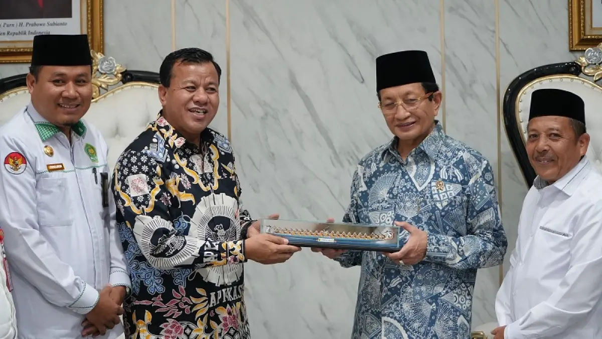 Bupati Kuansing H Suhardiman Amby menyerahkan miniatur jalur pada Menteri Agama RI KH Nazaruddin Umar saat silaturrahim dan mengundang membuka MTQ Riau di Kabupaten Kuansing, Selasa (14/4/2026) di Jakarta. (Diskominfos Kuansing)