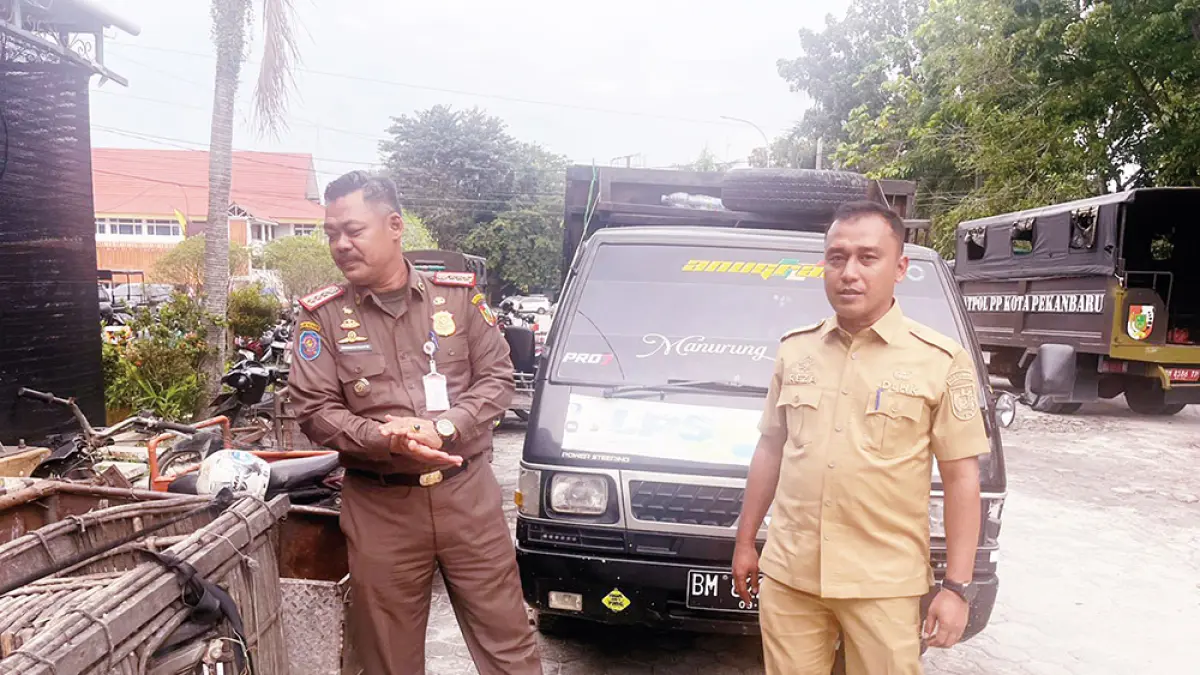 Kepala DLHK Pekanbaru Reza Aulia Putra (kanan) memperlihatkan angkutan sampah ilegal yang diamankan di Mako Satpol PP Pekanbaru, Senin (13/4/2026). (joko susilo)

