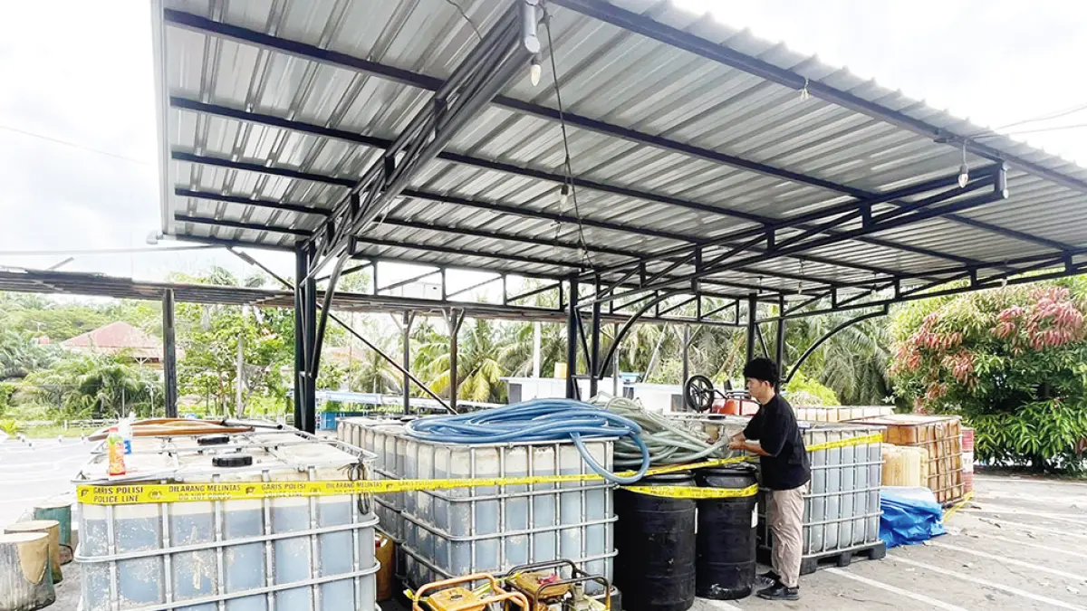 Unit Tipidter Polres Pelalawan memasang garis polisi pada barang bukti yang berhasil diamankan dari kasus penimbunan BBM bersubsidi jenis solar di Dusun Parit Melati, Kelurahan Teluk Dalam, Kecamatan Kuala Kampar, Senin (13/4/2026). (JPG)