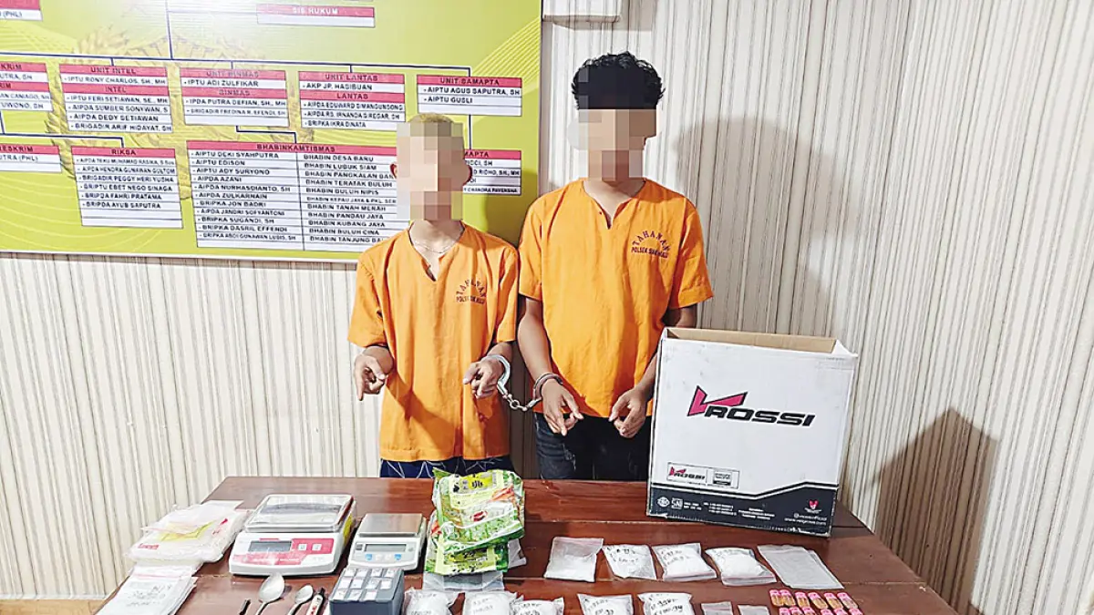 Dua tersangka sabu beserta barang bukti dihadirkan saat dilakukan pemeriksaan di Mapolsek Siak Hulu, Selasa (14/4/2026). (Humas Polres Kampar)
