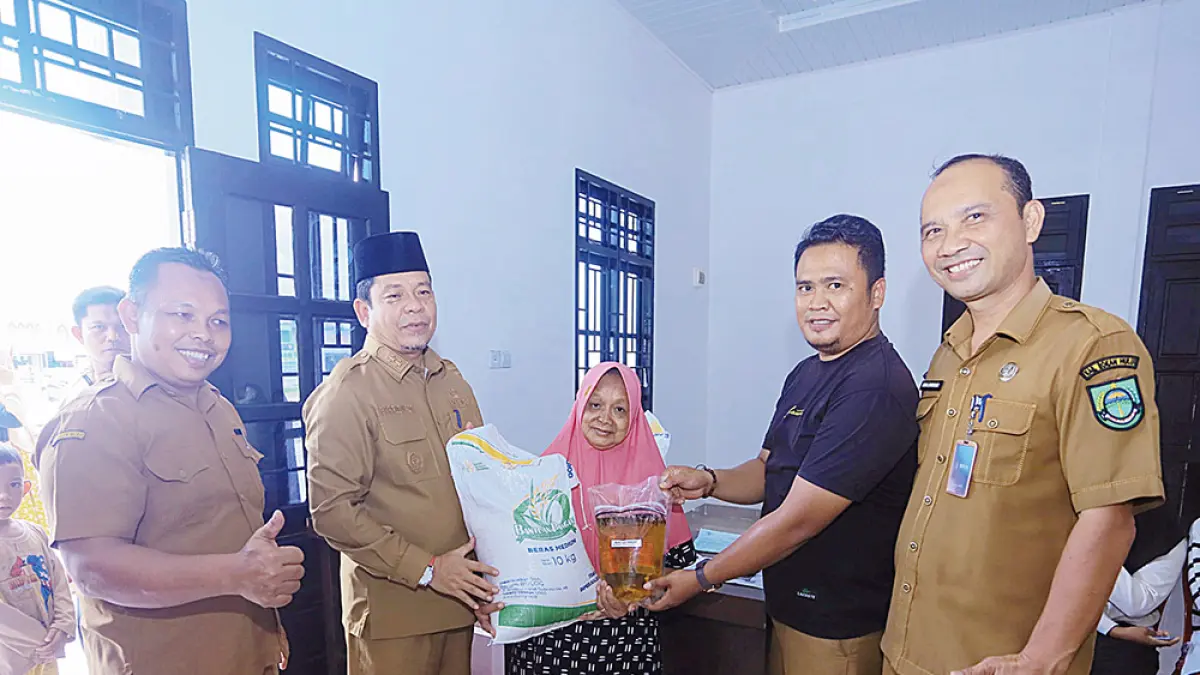 Wabup Rohul H Syafaruddin Poti SH MM menyerahkan secara simbolis bantuan bahan pangan kepada perwakilan penerima manfaat&nbsp;saat melakukan peninjauan dan pengawasan penyaluran bahan pangan dari Bulog Cabang Kampar di Kecamatan Tambusai Utara, Senin (13/4/2026) siang. (Prokopim Setda Rohul)