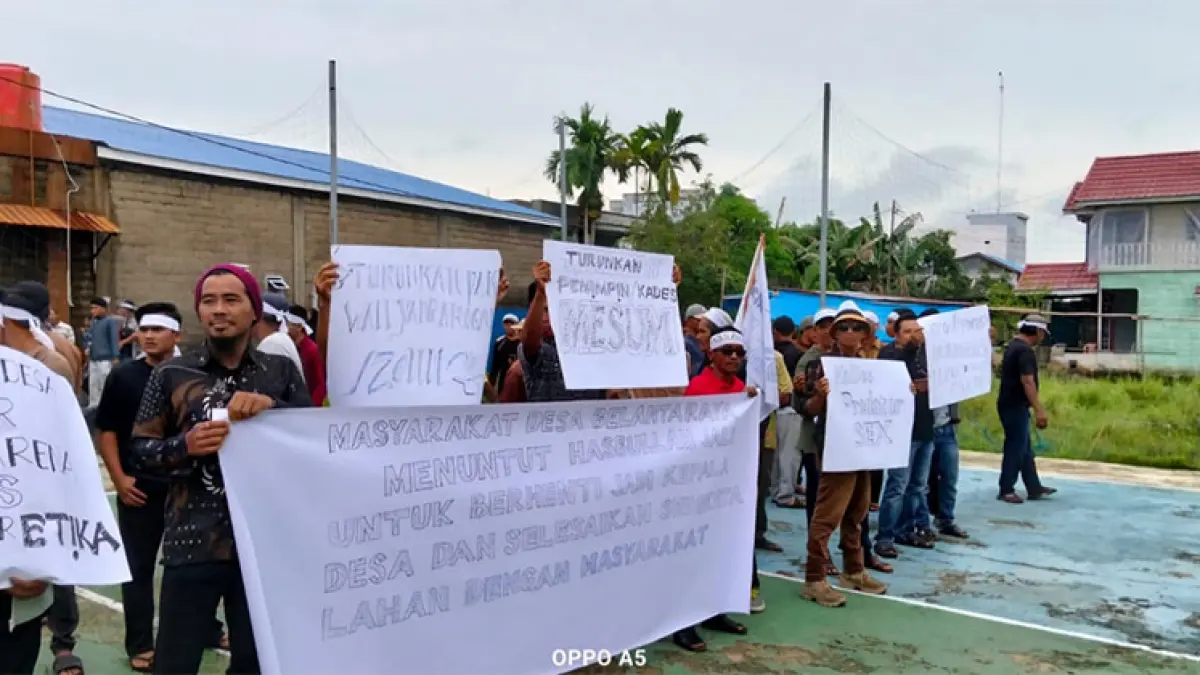 Masyarakat menggelar aksi sambil membentangkan banner mendesak kepala desa mengundurkan diri di Kantor Desa Belantaraya, Kecamatan Gaung, Kabupaten Indragiri Hilir, Rabu (15/4/2026). (Istimewa)