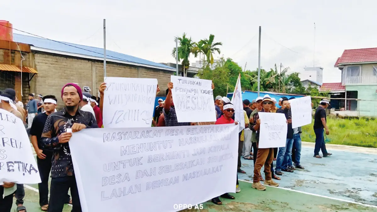 Masyarakat menggelar aksi sambil membentangkan banner mendesak Kepala Desa Belantaraya, Kecamatan Gaung, Kabupaten Indragiri Hilir mengundurkan diri dari jabatannya, Rabu (15/4/2026). (WARGA)
