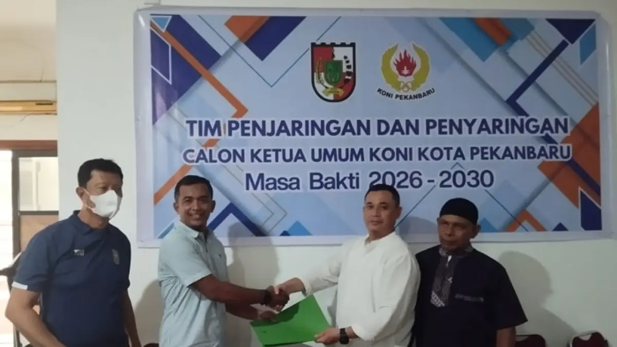Sekretaris TPP Bacalon Ketua KONI Pekanbaru, Matrap Binhar (kanan) meyerahkan formulir pendaftaran kepada Bacalon ketua KONI Pekanbaru Teguh Nugroho (kiri), pada Jumat (17/4/2026). (Dofi Iskandar/Riaupos.co)