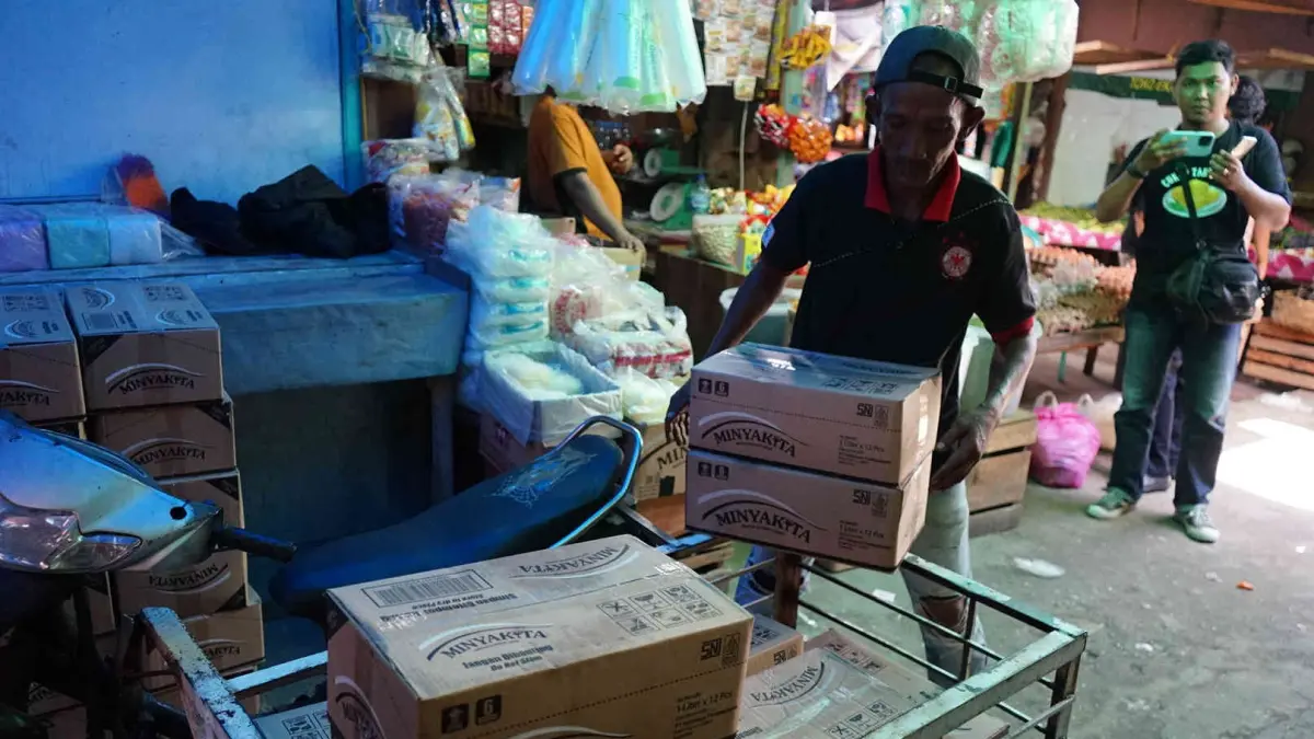 Susun Minyak : Buruh angkut menyusun minyak kita saat didistribusikan ke kios pedagang Pasar Cik Puan Pekanbaru, Kamis (16/4/2026). ft : EVAN GUNANZAR/RIAU POS