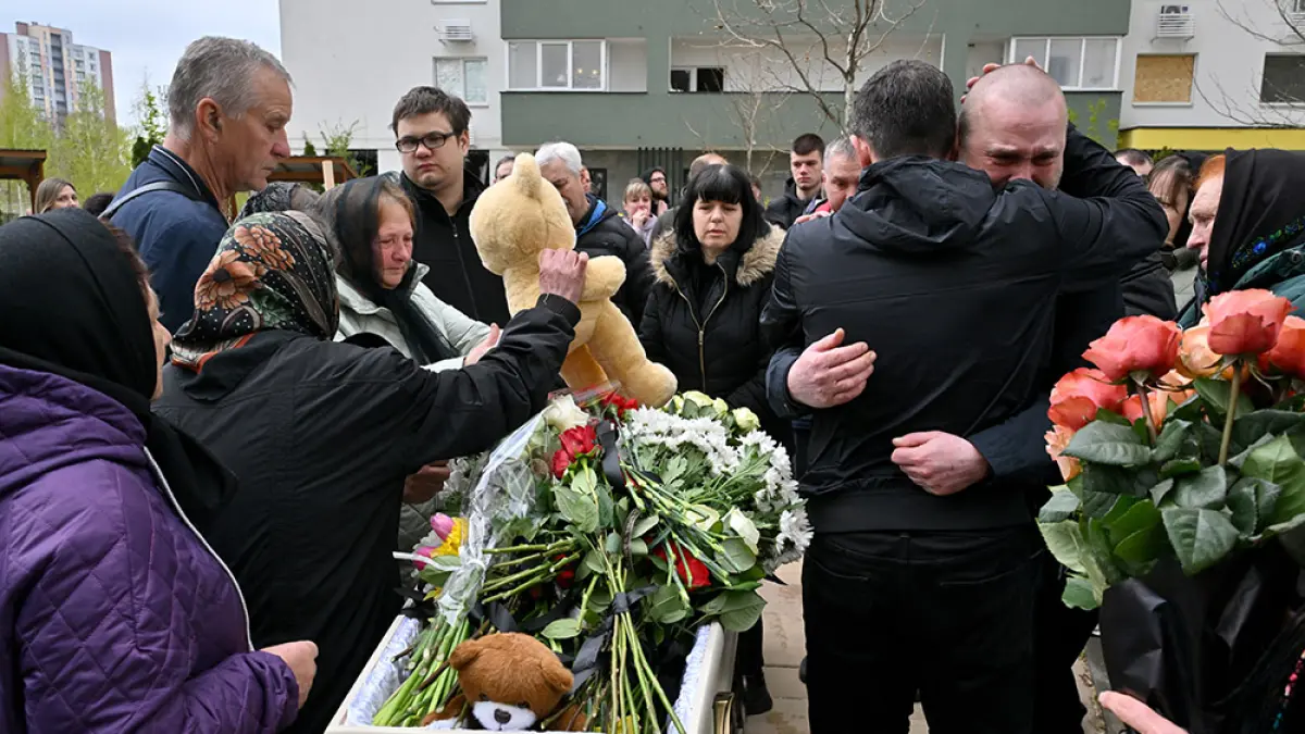 Orang tua, kerabat, dan warga membawa boneka di samping peti mati Maxim Vereshchuk, korban penembakan yang berusia 11 tahun di Kyiv, Ukraina, Sabtu (18/4/2026). (FOTO-FOTO Sergei SUPINSKY / AFP)