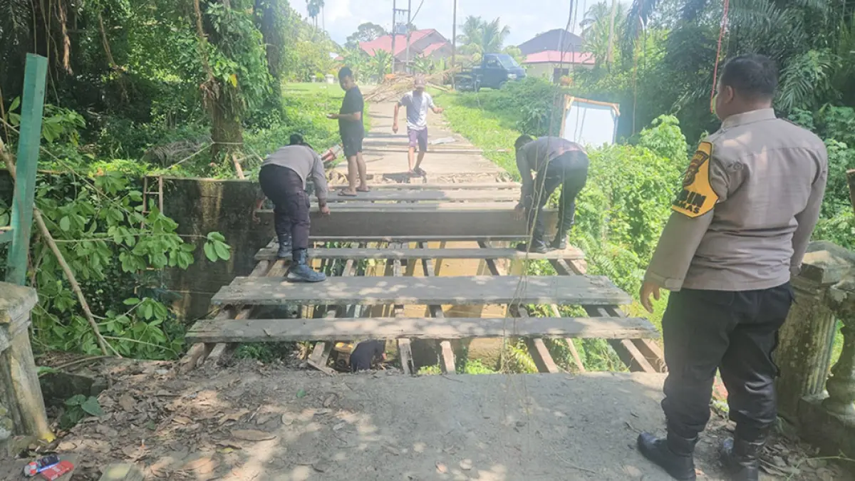 Personel Polda Riau dan Polres Kampar turun bersama membangun salah satu jembatan di Kecamatan Kuok, Kabupaten Kampar, Sabtu (18/4/2026). (HUMAS POLRES KAMPAR UNTUK RIAU POS)