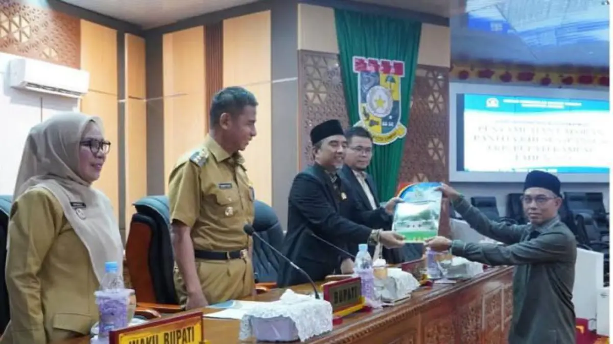 Juru bicara Pansus II Ristanto menyerahkan laporan Pansus kepada Ketua DPRD Kabupaten Kampar Ahmad Taridi  di ruang rapat paripurna DPRD Kampar, Senin (20/04/2026). (Kamaruddin/Riaupos.co)