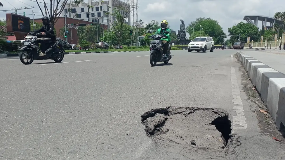 Tampak kondisi jalan berlubang hingga amblas di Jalan Sudirman,  tepatnya di depan gerbang Kantor Gubernur Riau, Selasa (21/4/2026). (Dofi Iskandar/Riaupos.co)