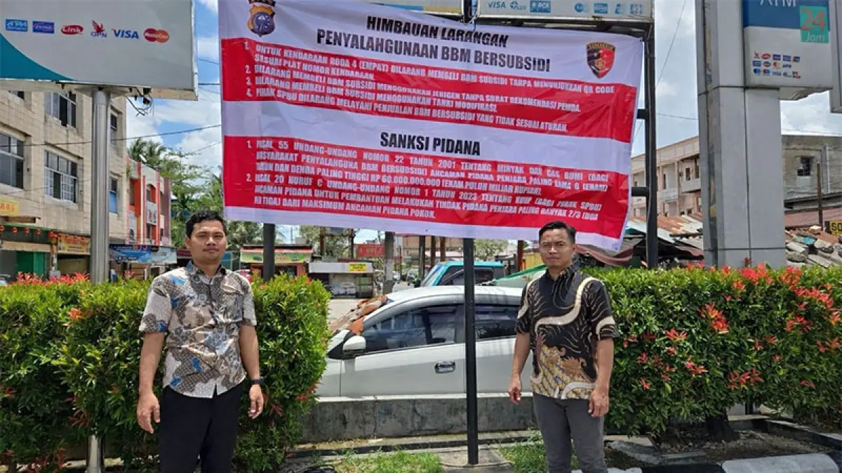 Petugas dari Subdit IV Ditreskrimsus Polda Riau saat memasang spanduk di salah satu SPBU, Rabu (22/4/2026. (ISTIMEWA)