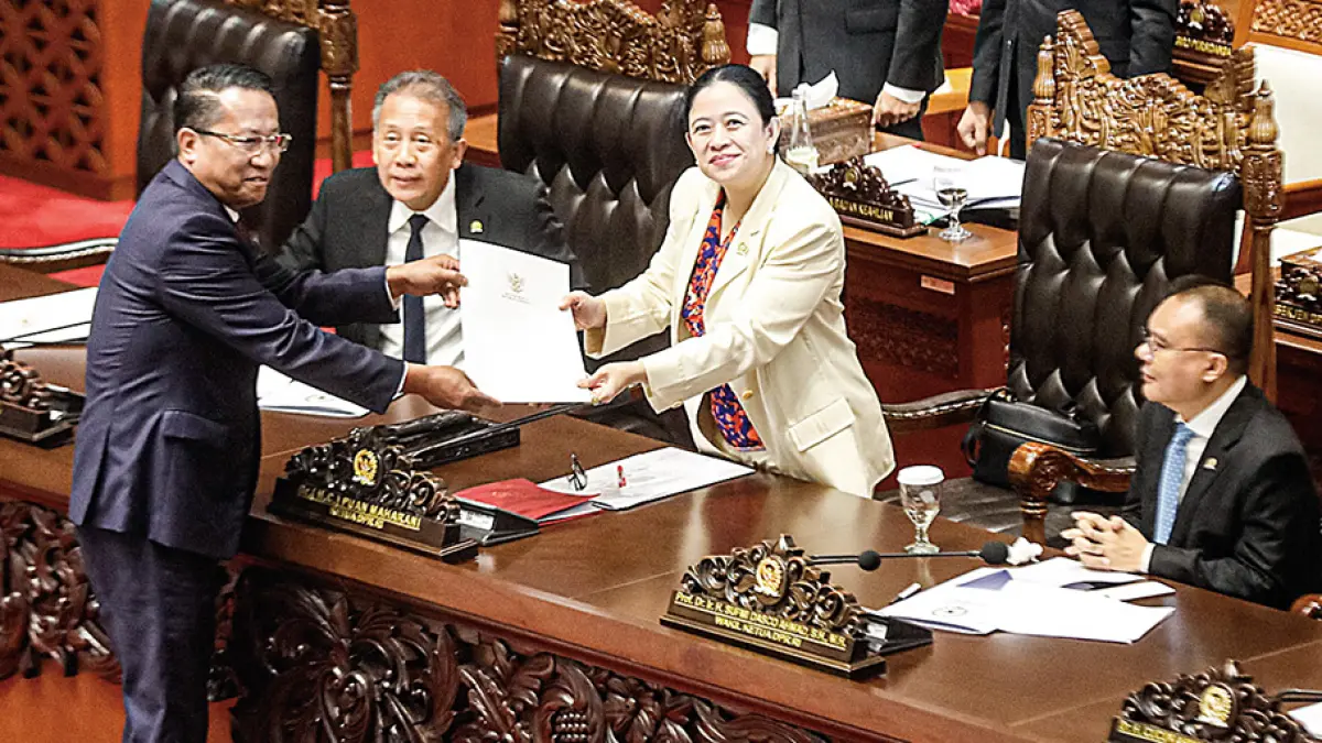 Menteri Hukum Supratman Andi Agtas (kiri) menyerahkan berkas pandangan pemerintah terkait RUU PPRT kepada Ketua DPR RI Puan Maharani (dua kanan) pada rapat paripurna ke-17 masa persidangan IV tahun sidang 2025-2026 di Jakarta, Selasa (21/4/2026). Dalam rapat tersebut DPR mengesahkan RUU PPRT menjadi undang-undang. (SALMAN TOYIBI/JAWA POS)