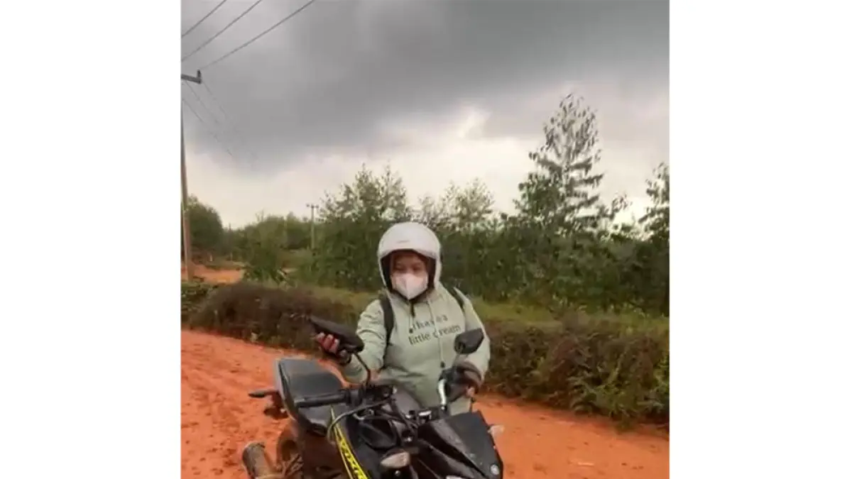 Guru SD 06 Tasik Betung, Kecamatan Sungai Mandau, Kabupaten Siak, Yanti, menuntun sepeda motor saat melintasi jalan licin, beberapa waktu lalu. (Guru SMPN 7 Sungai Mandau untuk Riau Pos)
