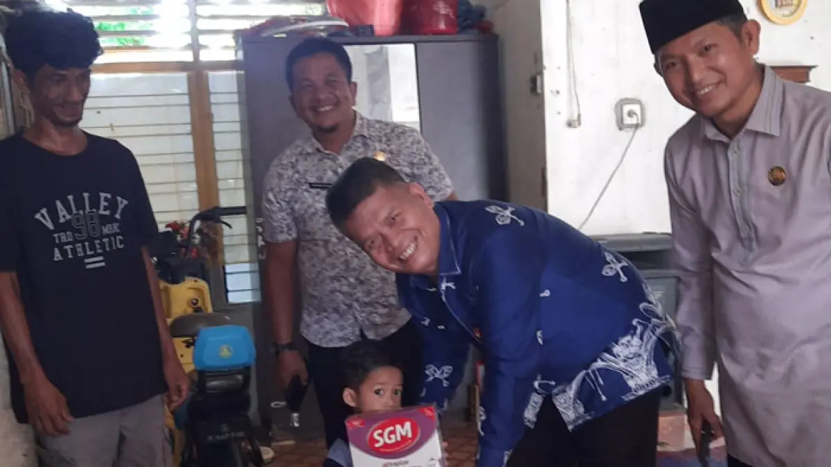 Kepala BKPP Kuansing, Dra Muradi MSi menyerahkan asupan makanan pada Zio penderita Stunting asal Desa Tanjung Simandolak Kecamatan Benai, Kamis (23/4/2026). (BKPP Kuansing untuk Riaupos.co)